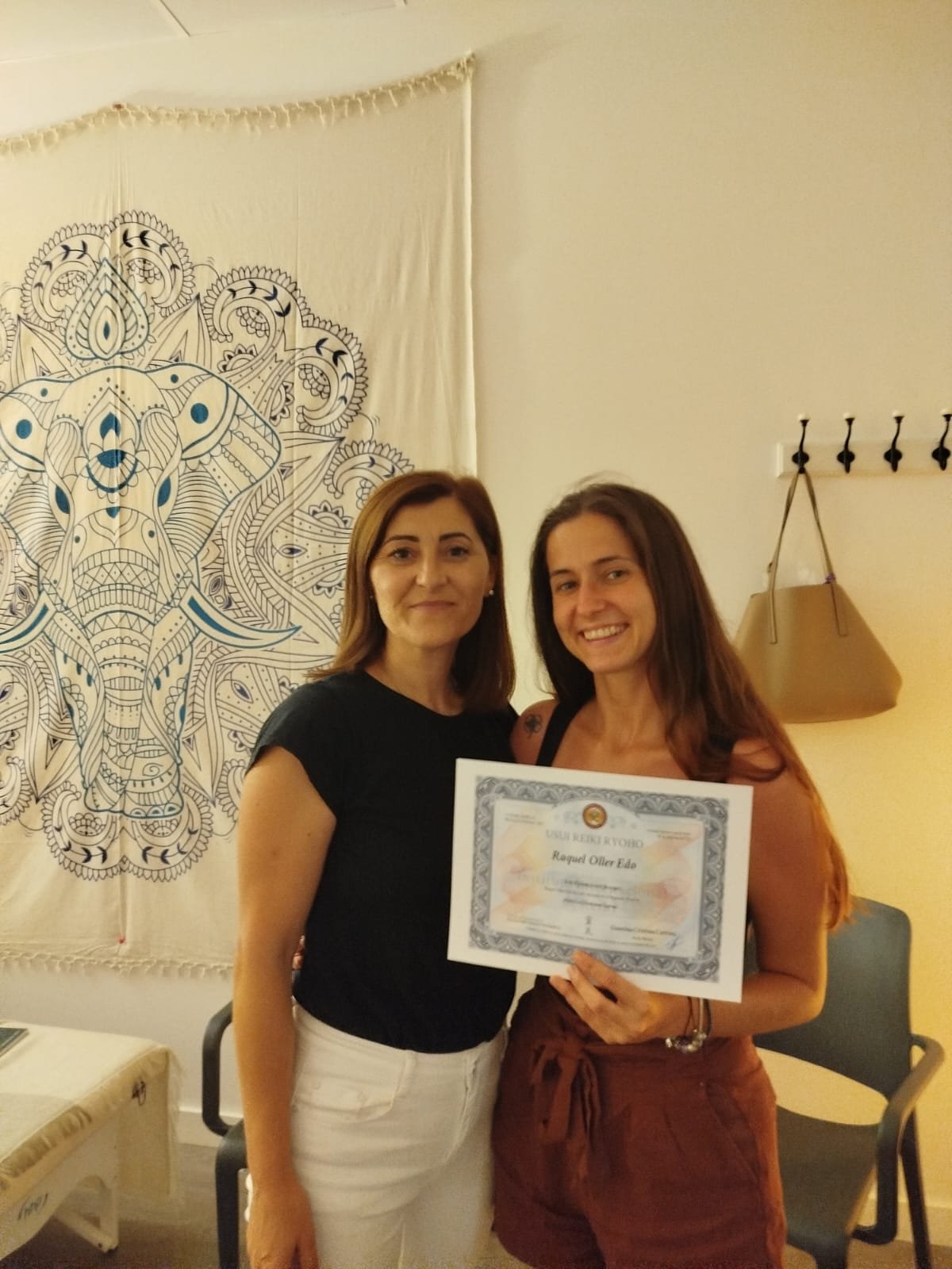 Geanina Cristina Catrina entregando el título a una alumna de Reiki
